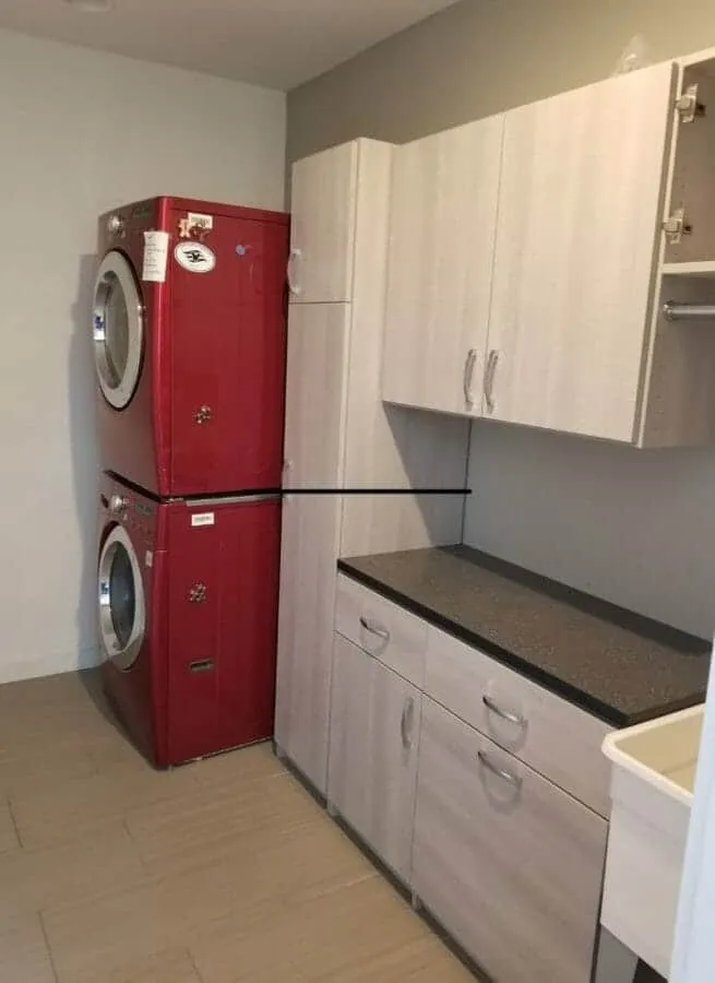 Laundry room with red stacked washer and dryer and custom cabinetry.