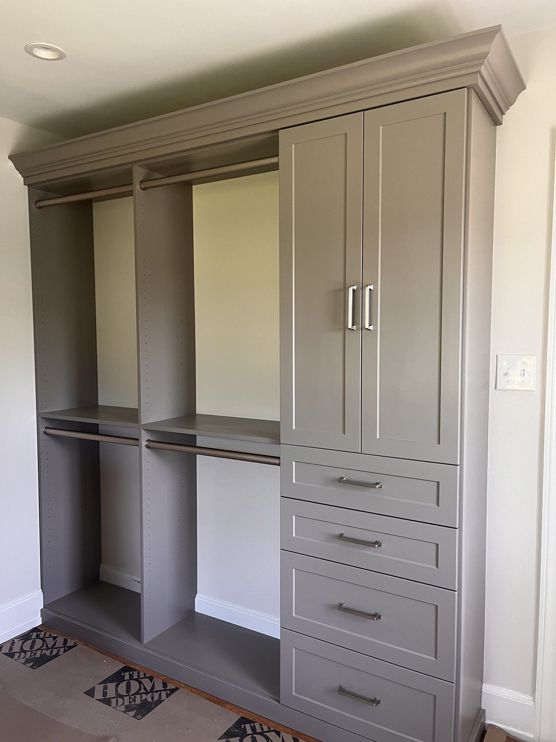 Gray wardrobe closet with crown molding, cabinet doors, drawers and open hanging