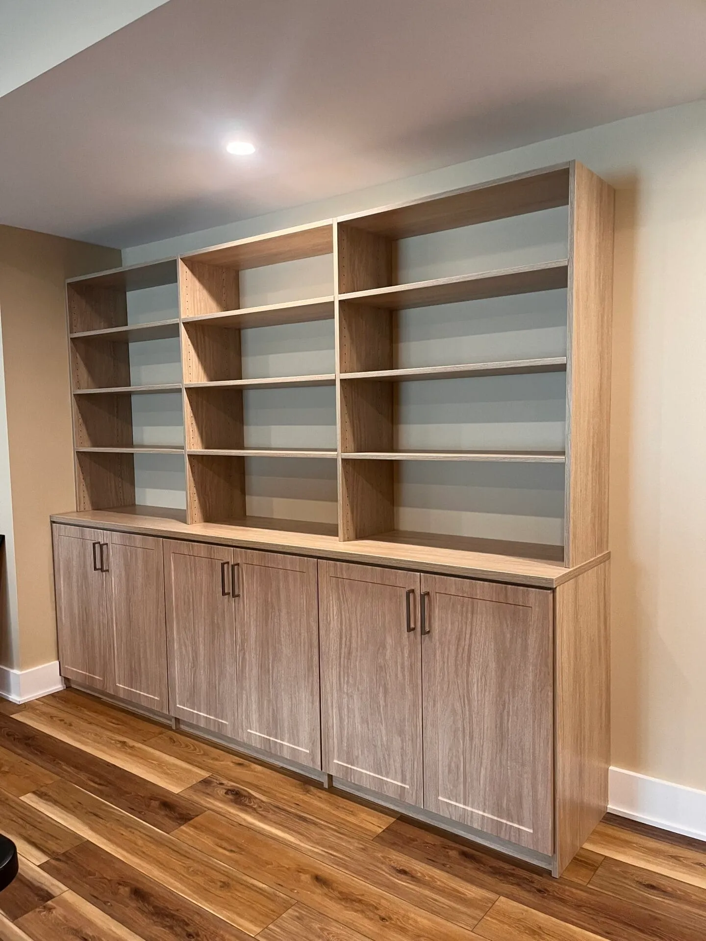 Custom built-in shelving with lower cabinets in a basement or living space.