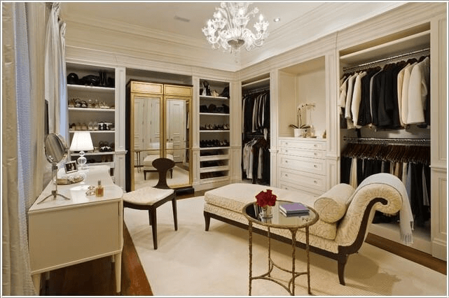 Luxury walk-in closet with built-in shelving, hanging rods, drawers, and seating area